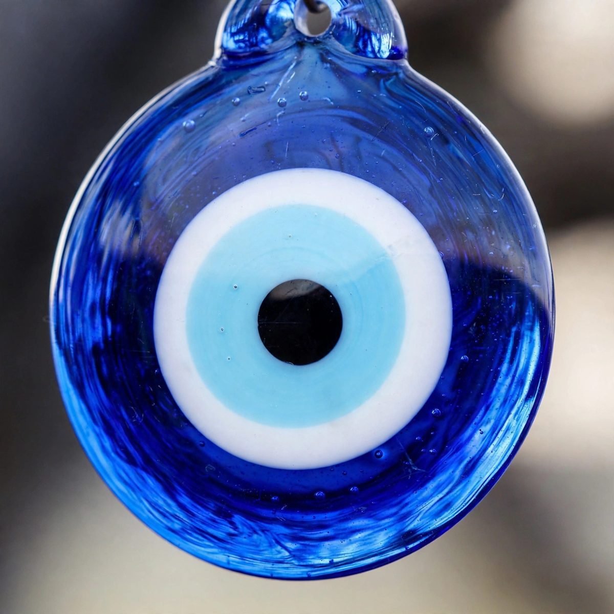 A close-up of a blue glass nazar amulet with concentric circles.